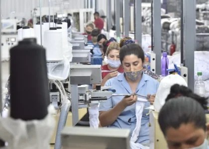 Des travailleurs réunis devant le portail fermé d'une usine textile à Pacheco