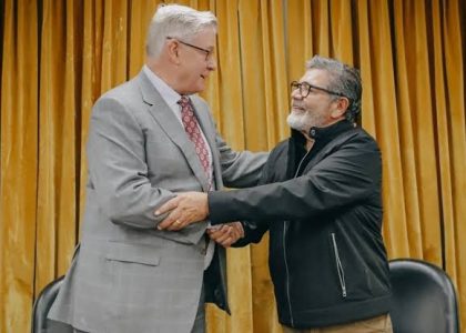 Representantes de Vicuña, UOCRA y la CGT San Juan firman un acuerdo laboral junto a carpetas sobre una mesa.